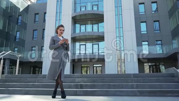 一位年轻漂亮的白种人商务女性走出办公楼视频的预览图