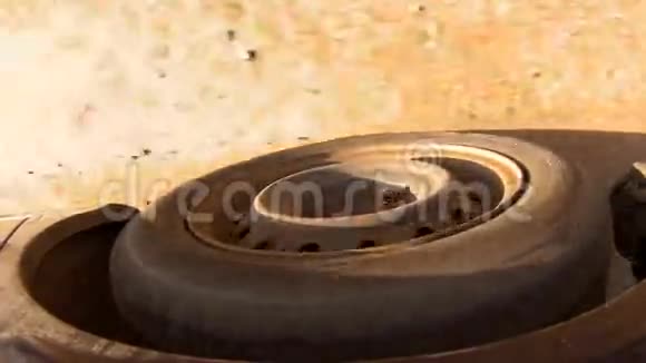 沥青路上深蓝色汽车的滚动橡胶轮胎视频的预览图