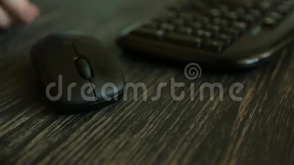 一个在电脑上工作的人在黑暗的桌面上点击鼠标的手视频的预览图
