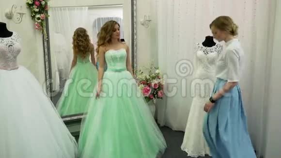 新娘在服装店买婚纱她正在挑选礼服设计师正在协助她视频的预览图
