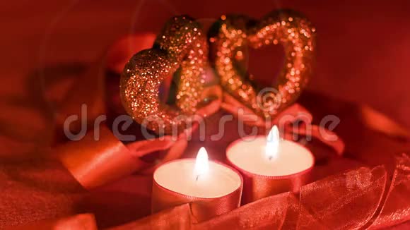 情人节两支蜡烛在坠落的心前燃烧特写视频的预览图