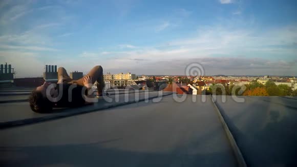 无呼吸的男孩坐在屋顶上俯瞰城市视频的预览图