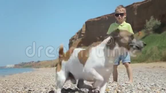 一个男孩赤脚走在海边的鹅卵石上视频的预览图