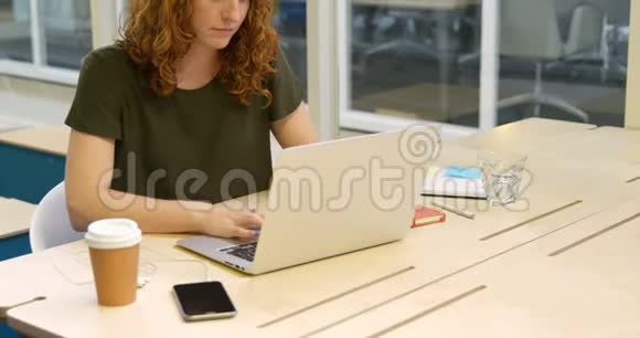 女商人在喝咖啡时使用笔记本电脑视频的预览图