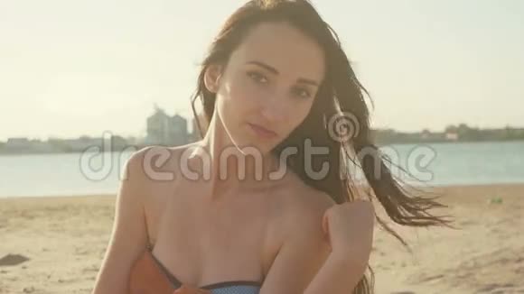 在夏天日落时坐在沙滩上的女人视频的预览图