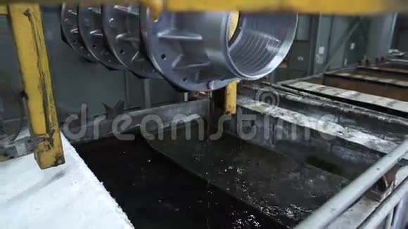 用水从工业浴缸中提起的金属部件镀锌视频的预览图