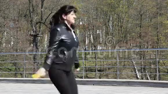 年轻的美女在城市公园的特写镜头里跳绳视频的预览图