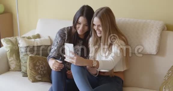 两个兴奋的年轻女子在看短信视频的预览图