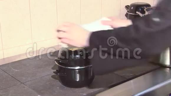 在餐厅厨房的工作灶台上用均匀的摇椅站立盖锅做饭做饭毛巾视频的预览图