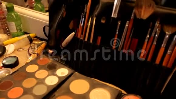 专业的化妆品化妆师在工作室的桌子上五彩的口红阴影化妆的基础视频的预览图