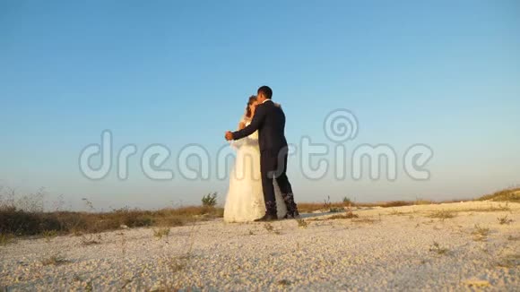 蜜月时的婚礼舞浪漫的男人和女人在沙滩上和天空跳舞视频的预览图