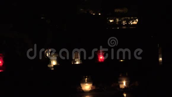 墓地装饰着五颜六色的蜡烛供所有圣徒在晚上度过4K视频的预览图