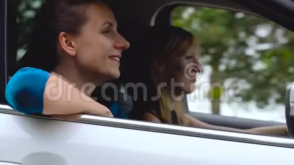 两个年轻的女人坐在车里玩得很开心慢动作视频的预览图