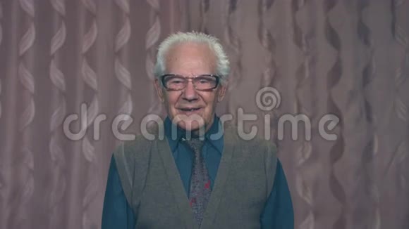 一位头发花白的祖父的肖像戴着粉红色背景的眼镜视频的预览图