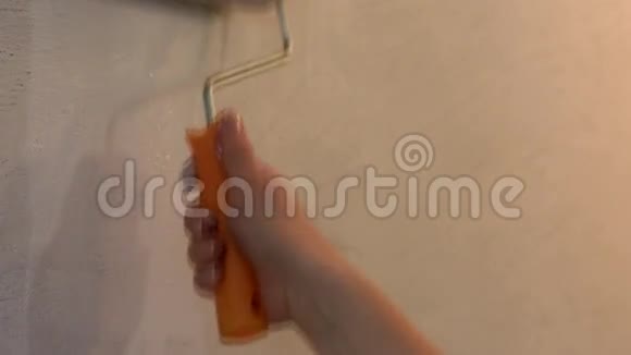 女画家用白色的滚筒工作视频的预览图