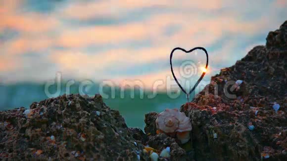 浪漫的概念岩石海岸上的心形火花和贝壳视频的预览图