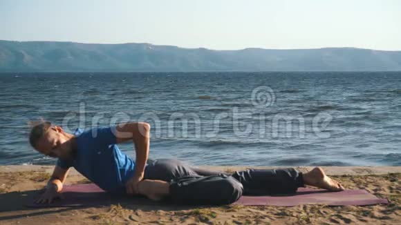 在海边练习瑜伽的年轻人视频的预览图