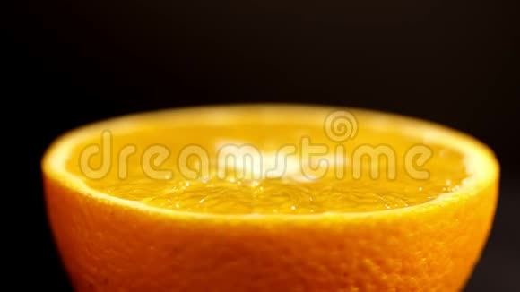 橙色在一个区域靠近黑色背景上明亮的柑橘橙色明亮的橙色围绕着自己旋转视频的预览图