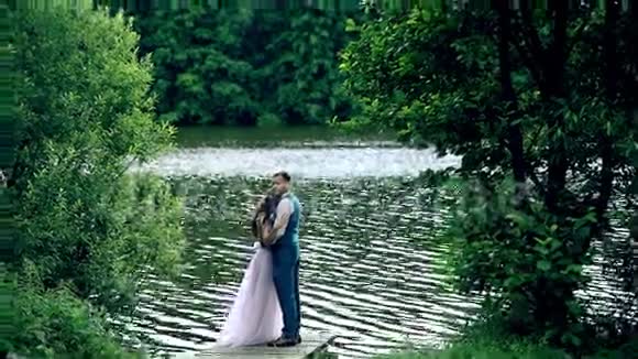 男人和女人年轻快乐的夫妇在湖边视频的预览图