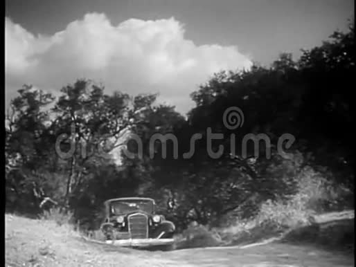 20世纪30年代汽车在丘陵乡村公路上缓慢行驶视频的预览图