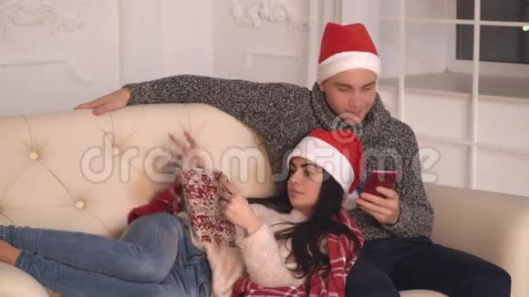 在圣诞节恋爱的情侣在公寓里放松视频的预览图