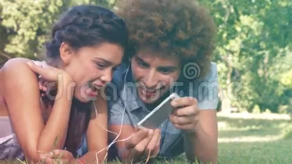 以高质量的形式一对夫妇躺在公园的草地上视频的预览图