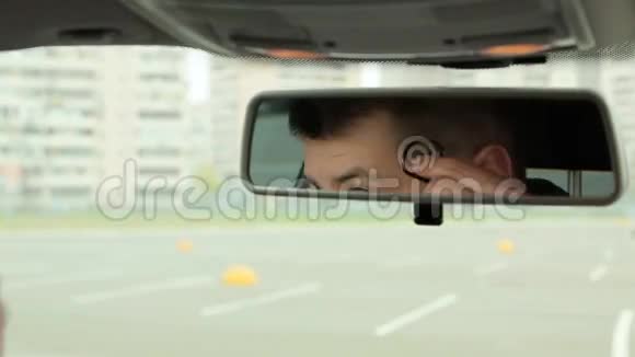 男人在车镜里打电话视频的预览图