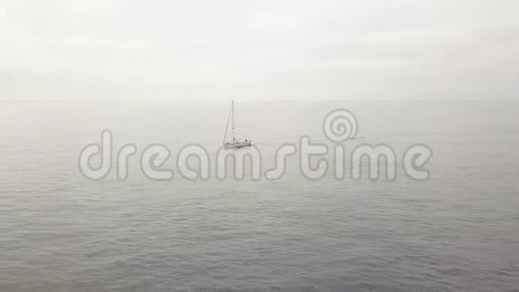 帆船在蔚蓝的大海中航行地平线上多云的天空景观空中景观视频的预览图