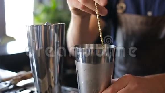 酒保在一个金属杯里加入了配料视频的预览图