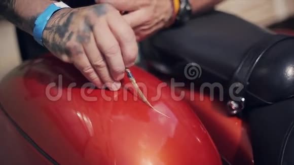 用小刷子观察摩托车的人漆红色灌装槽金色线条夏日Bikers视频的预览图