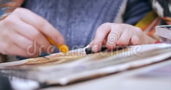 艺术家的年轻双手女艺术家用石墨铅笔绘制画布坐在桌子上画画布视频的预览图