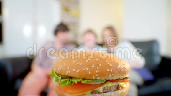 幸福的一家人想吃一个美味的汉堡包他们笑着向他吸引视频的预览图