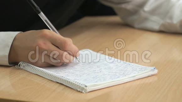 学生用钢笔在练习本上写课文视频的预览图