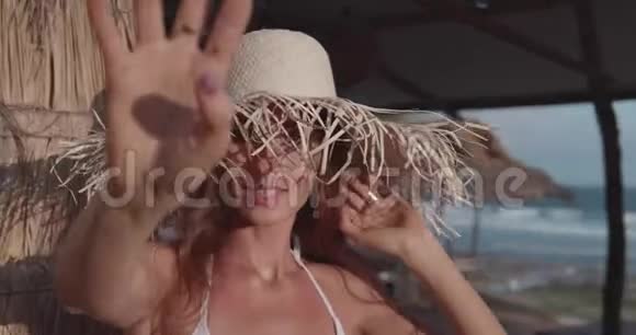 穿比基尼的美女在海滩附近摆着草帽视频的预览图