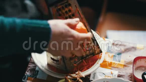 女性用胡萝卜在砧板上的烤盘上摩擦胡萝卜视频的预览图