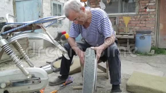 一位老人在村里的院子里修理摩托车视频的预览图