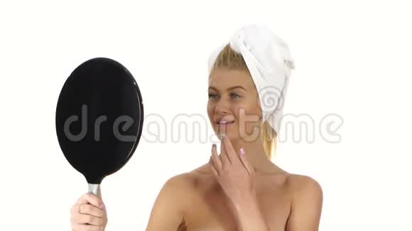 微笑的年轻女人涂面霜浴室视频的预览图