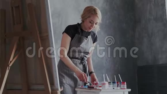 开朗的女人创造艺术品她在现代阁楼极简主义的室内画她画的是丙烯酸视频的预览图