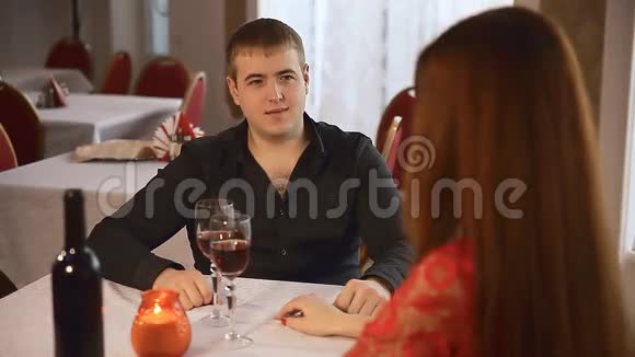 男人和女孩在餐厅约会浪漫的晚烛酒情人节视频的预览图