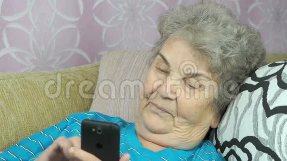 老年妇女在室内持有手机视频的预览图