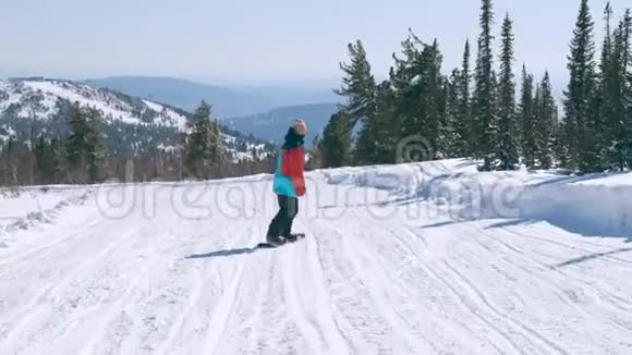 快乐的滑雪者在雪山的一个阳光明媚的冬日玩着快乐的滑雪板穿鲜艳颜色的男人视频的预览图