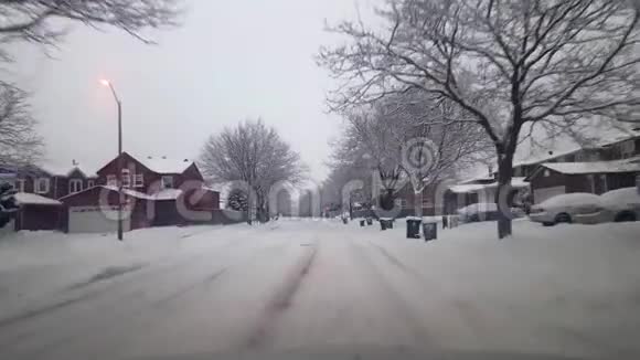 白天在雪域住宅区的郊区街道上开车司机的观点视频的预览图