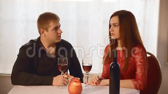 男人和女孩在餐厅约会浪漫情人节晚上蜡烛酒视频的预览图