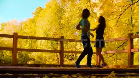 年轻的职业夫妇在桥上跳舞的剪影视频的预览图