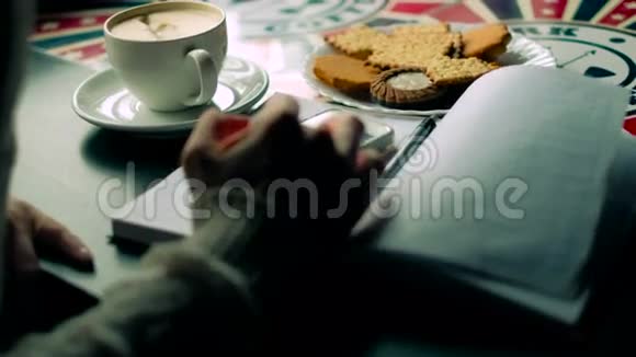 一个女孩在咖啡馆喝4k卡布奇诺电话视频的预览图