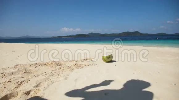 在海滩上喝椰子汁的男人视频的预览图