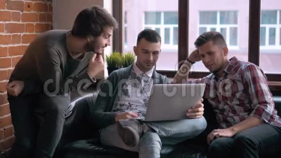 一群企业家在一间小办公室里一起工作和做笔记自由职业者会议带手提电脑的男人视频的预览图