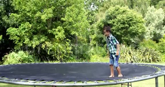 可爱的男孩在蹦床上玩耍和跳跃视频的预览图