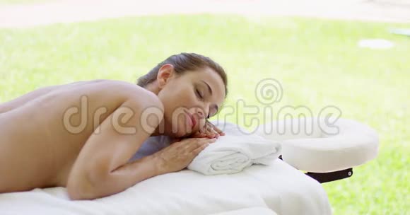 可爱的中年妇女躺在按摩床上视频的预览图