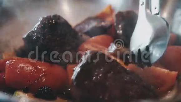 肉与西红柿辣椒胡萝卜一起炖与火钳混合视频的预览图